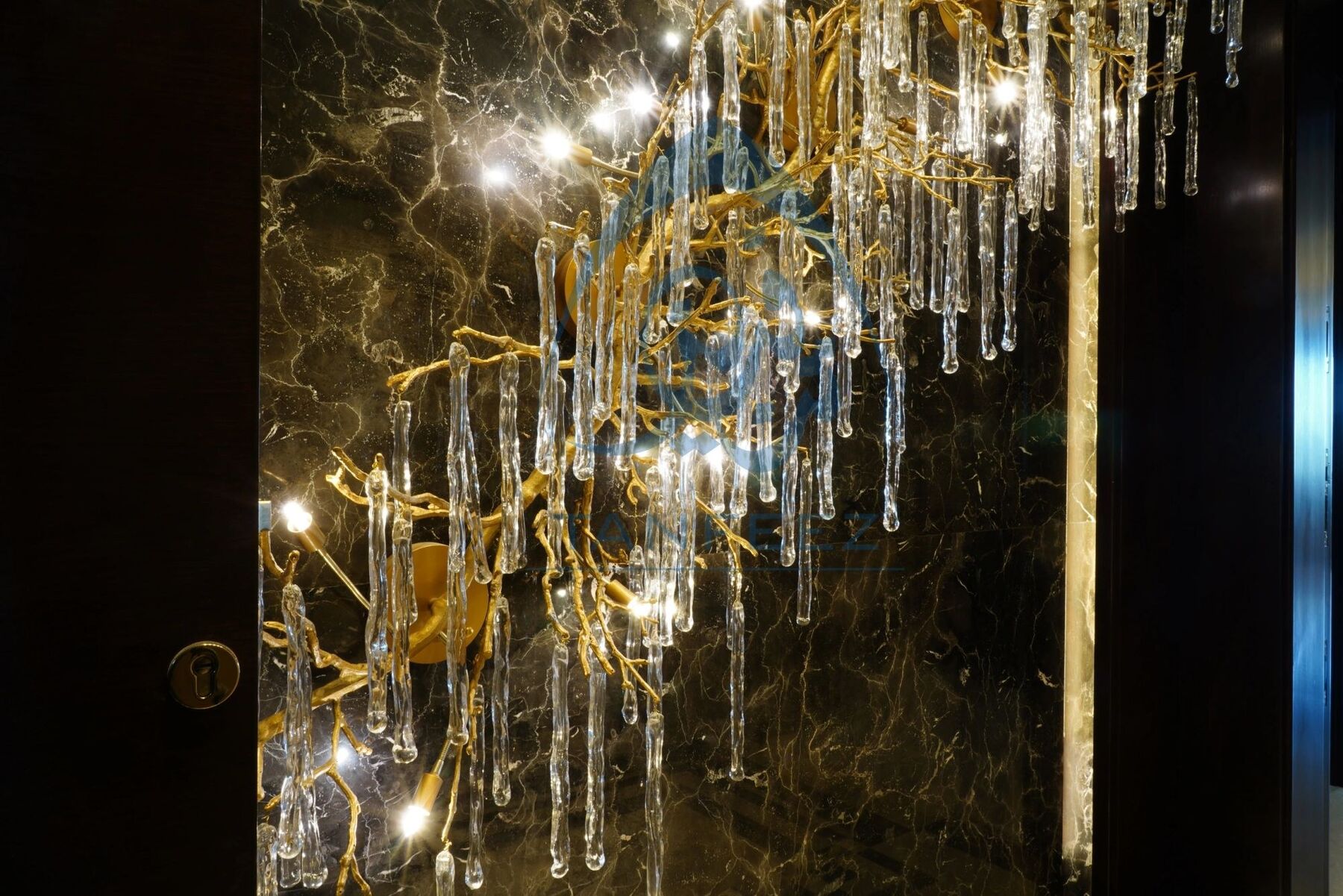 Detail of a sculptural crystal light against dark marble