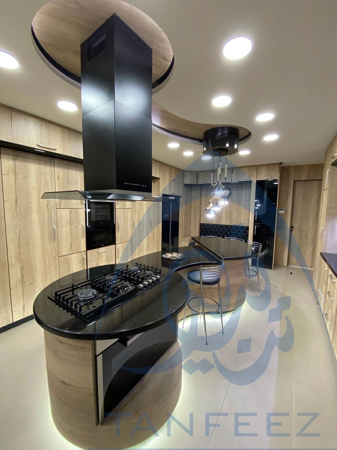 Kitchen with a round black island and timber cabinetry